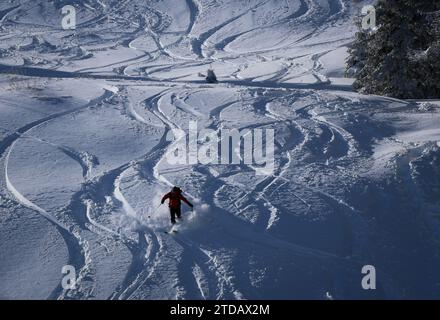 Winterwetter in Bulgarien. Ein Skifahrer fährt eine Skipiste mit Neuschnee hinunter. Stockfoto