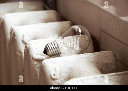 Glühlampe und Gusseisenbatterie in einer Wohnung in der Ukraine für die Küche, Licht und Wärme im Haus, Versorgungseinrichtungen Stockfoto