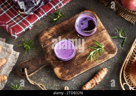 Violetter Kohlsaft in Glasbechern auf einem Tisch Stockfoto