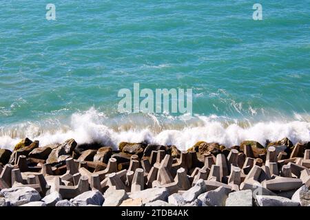 Wellen brechen über Felsen am Küstenrand Stockfoto