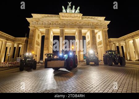 Berlin, Deutschland. Dezember 2023. Bauern aus Ostholstein stehen mit ihren Traktoren vor dem Brandenburger Tor. Hunderte von Landwirten haben sich nach Berlin begeben, um gegen die geplante Abschaffung der landwirtschaftlichen Dieselsubventionen zu demonstrieren. Quelle: Jörg Carstensen/dpa/Alamy Live News Stockfoto