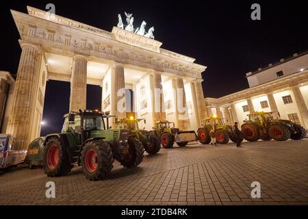 Berlin, Deutschland. Dezember 2023. Bauern aus Ostholstein stehen mit ihren Traktoren vor dem Brandenburger Tor. Hunderte von Landwirten haben sich nach Berlin begeben, um gegen die geplante Abschaffung der landwirtschaftlichen Dieselsubventionen zu demonstrieren. Quelle: Jörg Carstensen/dpa/Alamy Live News Stockfoto