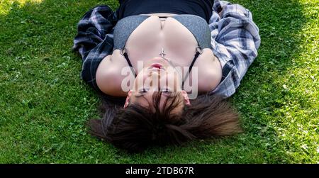 Eine atemberaubende und üppige Frau genießt sich bei warmem Wetter und posiert für ein Foto in Dundee, Schottland Stockfoto