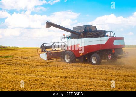 Ein Mähdrescher steht nach der Weizenernte an einem sonnigen Herbsttag auf einem Feld. Ernte, Landwirtschaft. Stockfoto