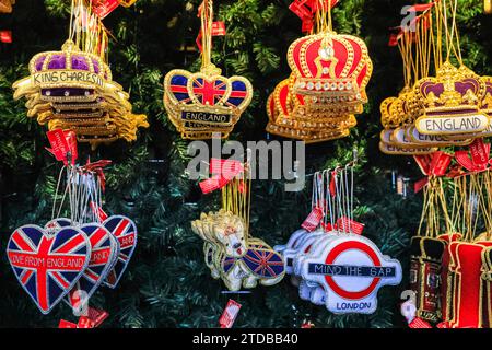 London, Großbritannien. Dezember 2023. Ein Stall mit Weihnachtsbaumschmuck im Royal- und London-Stil wirkt lebendig und festlich. Der Weihnachtsmarkt vor der National Gallery am Trafalgar Square erweist sich als beliebt bei den Massen von Touristen und lokalen Besuchern, die Snacks, heiße Getränke und handwerkliche Weihnachtsgeschenke suchen. Quelle: Imageplotter/Alamy Live News Stockfoto