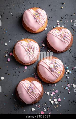 Romantische Mono-Portion zum valentinstag als besonderer Snack. Rosafarbene Mono-Portion in Herzform mit Streuseln. Stockfoto