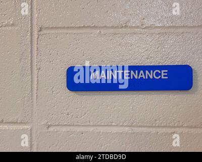 Blaues Wartungsschild mit braille-schrift, auf weiß lackierter Blockwand. Stockfoto