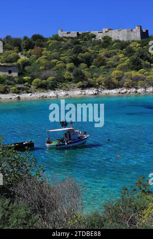 139 kleines handwerkliches Fischerboot, das in der Bucht von Porto Palermo am Fuße des Ali Pascha der Burg Tepelene vor Anker liegt. Himare-Albanien. Stockfoto