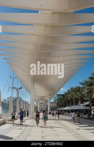 Besucher und Einheimische spazieren unter der Pérgola Zigzagueante (Zickzack-Pergola), Muelle UNO, Málaga, Spanien. Das Kreuzfahrtschiff Club Med 2 liegt vor Anker. Stockfoto