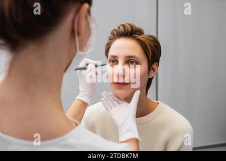 Eine junge Frau berät eine Kosmetikerin über ihr Gesicht. Stockfoto