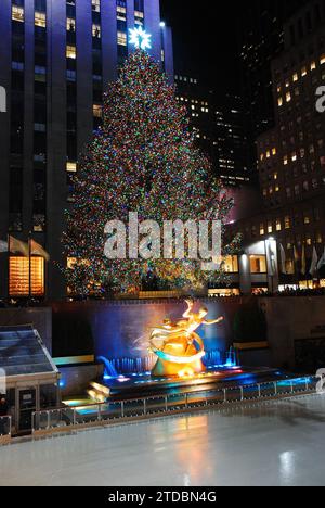 Der Weihnachtsbaum im Rockefeller Center leuchtet vor der berühmten Eislaufbahn in New York City Stockfoto
