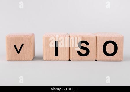 Internationale Organisation für Normung. Holzwürfel mit Häkchen und Abkürzung ISO auf hellgrauem Hintergrund Stockfoto