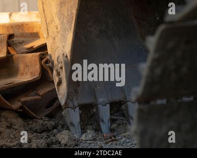 Bagger mit Metallstange auf Baustelle geparkt. Baggerlader nach der Arbeit. Erdbewegungsmaschine. Ausgrabungsfahrzeug. Baustelle mit Bagger. Stockfoto