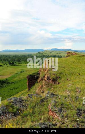 Steinformationen aus geschichtetem rotem Sandstein auf einem hohen Hügel in einem malerischen Tal an einem sonnigen Sommertag. Truhen in den Bergen, Khakassia, Siber Stockfoto