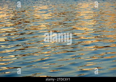 Goldene Sonnenlichtreflexionen auf Wasser, Hintergrund Stockfoto