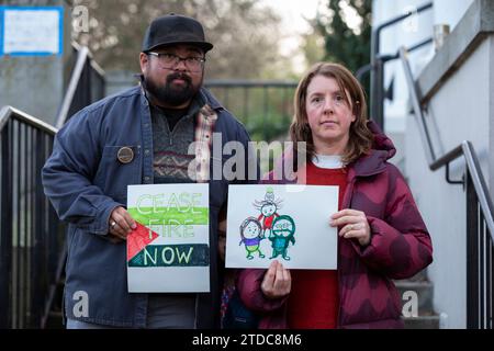Seattle, Washington, USA. Dezember 2023. Jay Guerrero (links) und Robyn Jordan (mit ihrem schüchternen Kind) posieren mit ihren Zeichnungen, die Washington Senator Patty Murray im Rainier Arts Center überreicht werden. Die jüdische Stimme für den Frieden organisierte die Porträts für Palästina-Veranstaltung zur Unterstützung eines Waffenstillstands in Gaza. Quelle: Paul Christian Gordon/Alamy Live News Stockfoto