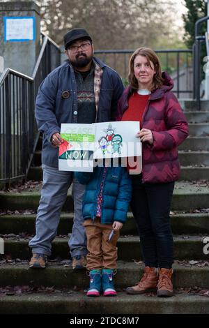 Seattle, Washington, USA. Dezember 2023. Jay Guerrero (links) und Robyn Jordan (mit ihrem schüchternen Kind) posieren mit ihren Zeichnungen, die Washington Senator Patty Murray im Rainier Arts Center überreicht werden. Die jüdische Stimme für den Frieden organisierte die Porträts für Palästina-Veranstaltung zur Unterstützung eines Waffenstillstands in Gaza. Quelle: Paul Christian Gordon/Alamy Live News Stockfoto