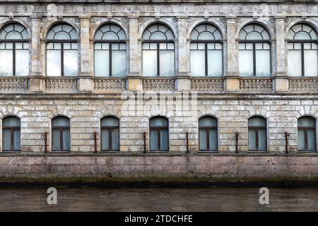 Hintergrundstruktur einer alten Hauswand im klassischen Stil mit Bogenfenstern, Blick auf den Fluss. Kaliningrad Stockfoto