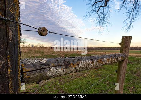 Nahaufnahme einer hölzernen Strebe auf einem elektrischen Zaun für eine Viehweide. Stockfoto