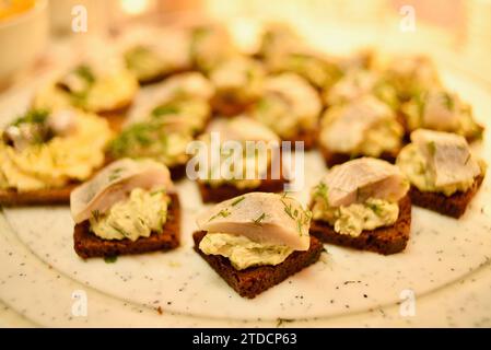 Traditioneller geräucherter Hering auf estnischem Roggenbrot als Fingerfood-Vorspeise, die am Lebensmittelstand auf dem Weihnachtsmarkt in der Altstadt von Tallinn, Estland, verkauft wird Stockfoto