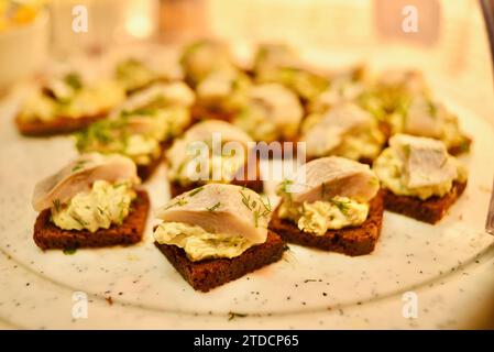 Traditioneller geräucherter Hering auf estnischem Roggenbrot als Fingerfood-Vorspeise, die am Lebensmittelstand auf dem Weihnachtsmarkt in der Altstadt von Tallinn, Estland, verkauft wird Stockfoto