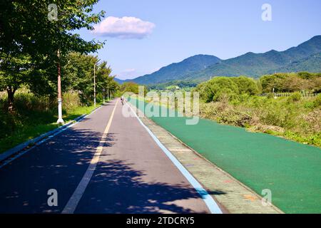 Hanam City, Südkorea - 1. Oktober 2023: Ein ruhiger Radweg, der von Bäumen gesäumt ist und an einen Wanderweg grenzt Stockfoto