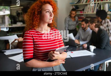 Porträt einer jungen glücklichen Erfolgsfrau, die an einem modernen Arbeitsplatz arbeitet, Startup-Mitarbeiter-Konzept Stockfoto