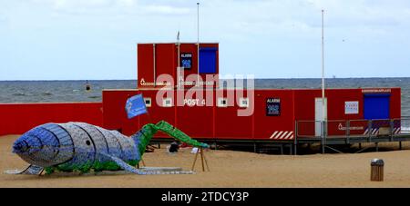 Scheveningen, Niederlande - 9. Juli 2019 Gebäude des niederländischen Rettungsschwimmers am Strand von Scheveningen. Vor dem Gebäude liegt ein Wal aus Plast Stockfoto