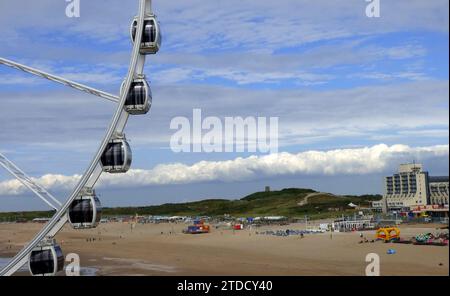 Scheveningen, Niederlande - 9. Juli 2019 Blick auf Waggons des Riesenrades in Scheveningen. In der Ferne: Der Strand, die Dünen und ein Hotel von C Stockfoto