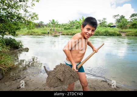 Niño recogiendo grava, Río Cuatro Chorros, Lancetillo - La Parroquia, Franja Transversal del Norte, departamento de Quiché, Guatemala Stockfoto
