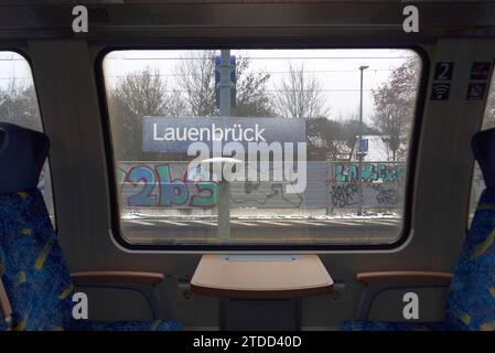 Blick aus einem Regionalzug der Bahngesellschaft Metronom auf das Stationsschild im Bahnhof Lauenbrück Landkreis Rotenburg/Wümme in Niedersachsen. *** Blick von einem Metronom Regionalzug auf das Bahnhofsschild am Bahnhof Lauenbrück im Landkreis Rotenburg Wümme in Niedersachsen Stockfoto