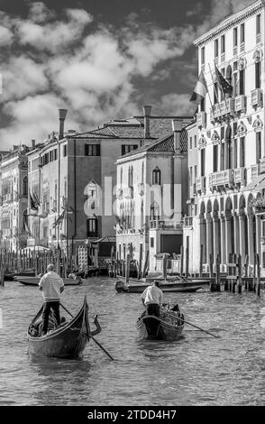 Zwei Gondoliere überqueren den berühmten Canal Grande in Venedig, Italien, in Schwarz-weiß Stockfoto