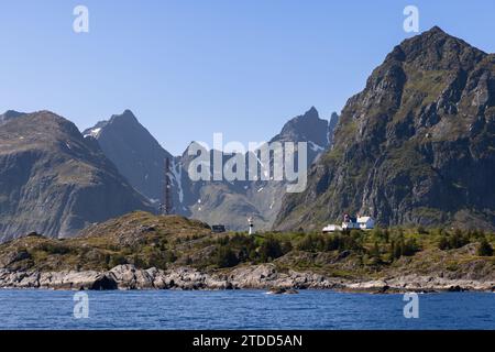 Ein malerischer Blick auf die Nordsee mit einer Bergkette, die sich über ruhigen Gewässern erhebt, mit Leuchttürmen in der Nähe von Moskenes auf den Lofoten-Inseln, Norwegen Stockfoto