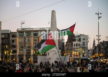 Die Menschen halten palästinensische Flaggen, um den Palästinensern am Dam-Platz in Amsterdam, Niederlande, ihre Unterstützung zu zeigen, am 27. Dezember 2023. Stockfoto