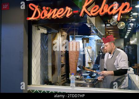 Istanbul, Türkei – 12. Dezember 2023: Ein Küchenchef schneidet in einem Street Food Shop traditionelle türkische Speisen Döner Kebab Stockfoto