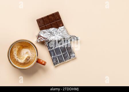 Coffee Break Bliss: Schokoladenriegel kombiniert mit einer Tasse Kaffee. Flache Ladefläche mit Kopierraum Stockfoto