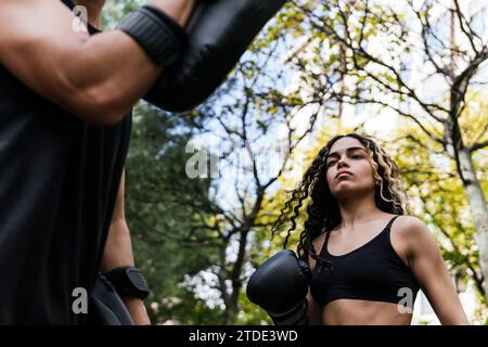 Frau, die mit einem Trainer im Freien Ringen übt Stockfoto