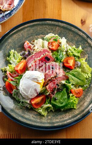 Salat mit pochiertem Ei und gebratenem Thunfisch Stockfoto