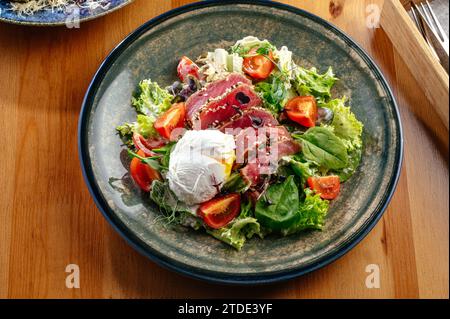 Salat mit pochiertem Ei und gebratenem Thunfisch Stockfoto