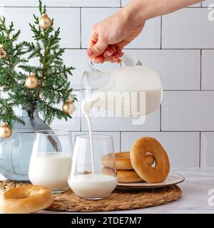 Die Hand einer Frau gießt Milch in ein Glas Stockfoto
