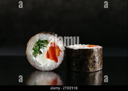 Japanische Sushi-Rolle auf dunklem Hintergrund mit Reflexion Stockfoto