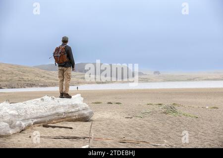 Ein älterer Mann steht auf dem Log in Point Reyes National Seashore Stockfoto