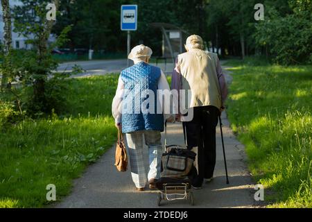 Der alte Mann und die alte Frau tragen einen Wagen. Stockfoto