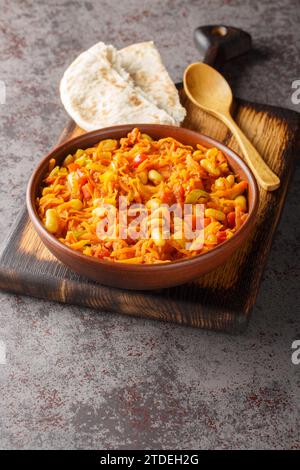 Chakalaka ist ein südafrikanisches Gemüsegericht, das normalerweise scharf ist und traditionell mit Brotnähe auf der Schüssel auf dem Tisch serviert wird. Vertikal Stockfoto