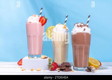 Set aus erfrischenden Sommermilchshakes oder Smoothies mit klassischem, köstlichem Geschmack - Vanille-Zitrone, Erdbeere, Schokolade, mit Schlagsahne und Garnierung, Stockfoto