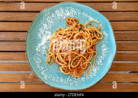 Ein Blick aus der Vogelperspektive über einen Teller mit frischen italienischen Spaghetti Bolognese auf einem Holztisch Stockfoto