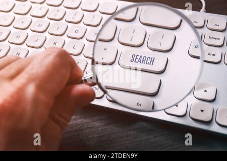 Taste der Suchtaste auf der Computertastatur durch Lupe, selektiver Fokus Stockfoto