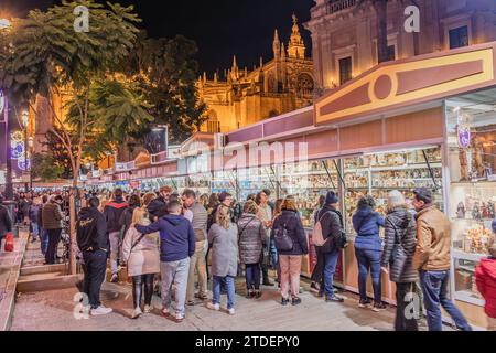 Sevilla, Spanien - 16. Dezember 2023: Weihnachtsmärkte rund um die Kathedrale von Sevilla zu weihnachten mit Menschenmassen, die typische Einkaufsmöglichkeiten machen. Ln Stockfoto