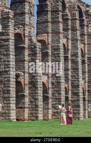 Merida, Spanien - 4. Juni 2023: Junge Reenactor Frauen neben dem Aquädukt Los Milagros. Emerita Ludica Festival 2023, Merida, Spanien Stockfoto