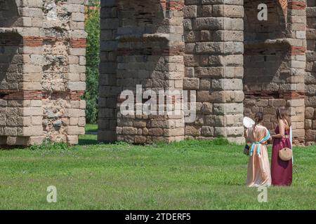 Merida, Spanien - 4. Juni 2023: Junge Reenactors Frauen neben dem Aquädukt Los Milagros. Emerita Ludica Festival 2023, Merida, Spanien Stockfoto